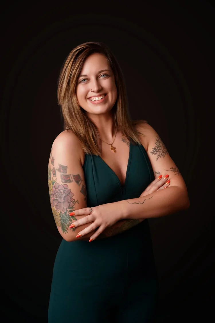 Stephanie Bosworth, wedding and portrait photographer at Emerald Photography in Johnstown, PA, smiling in a dark green top